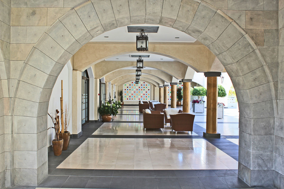 Archway corridor with seating and plants at a Tenerife location.