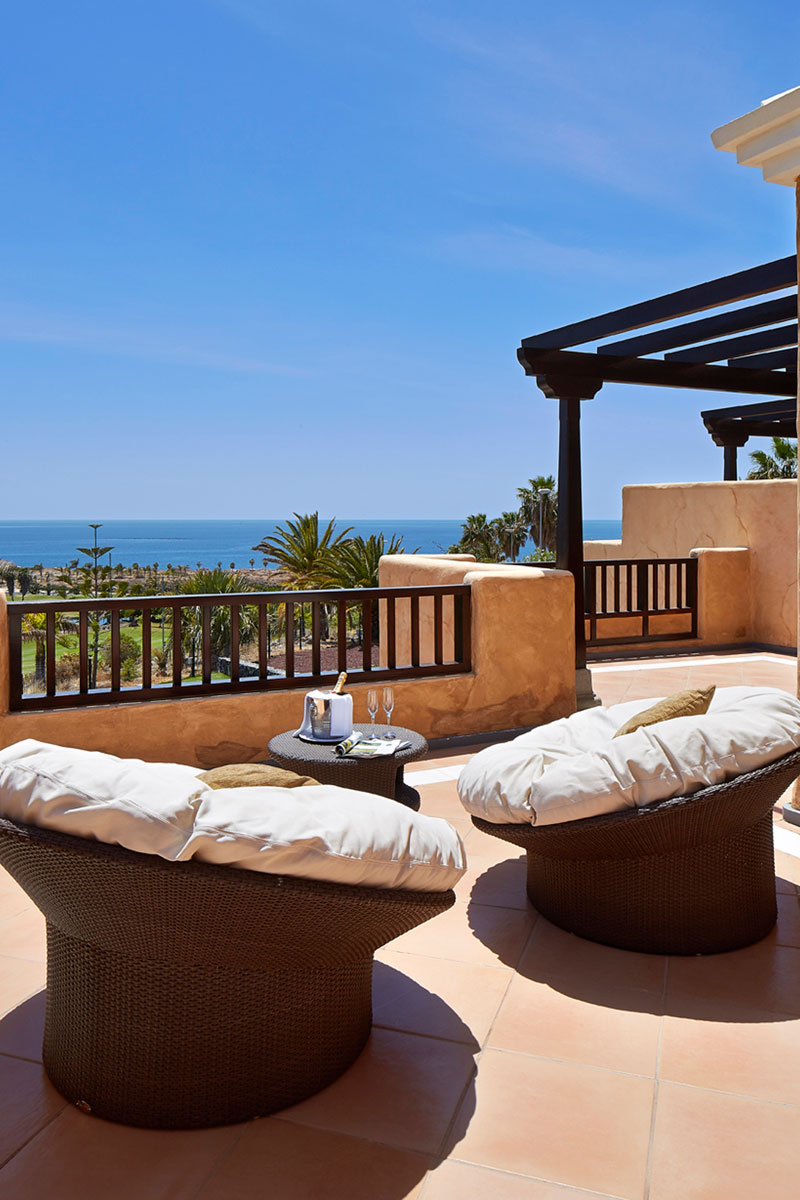 Terrace with cushioned chairs and ocean view in Tenerife.