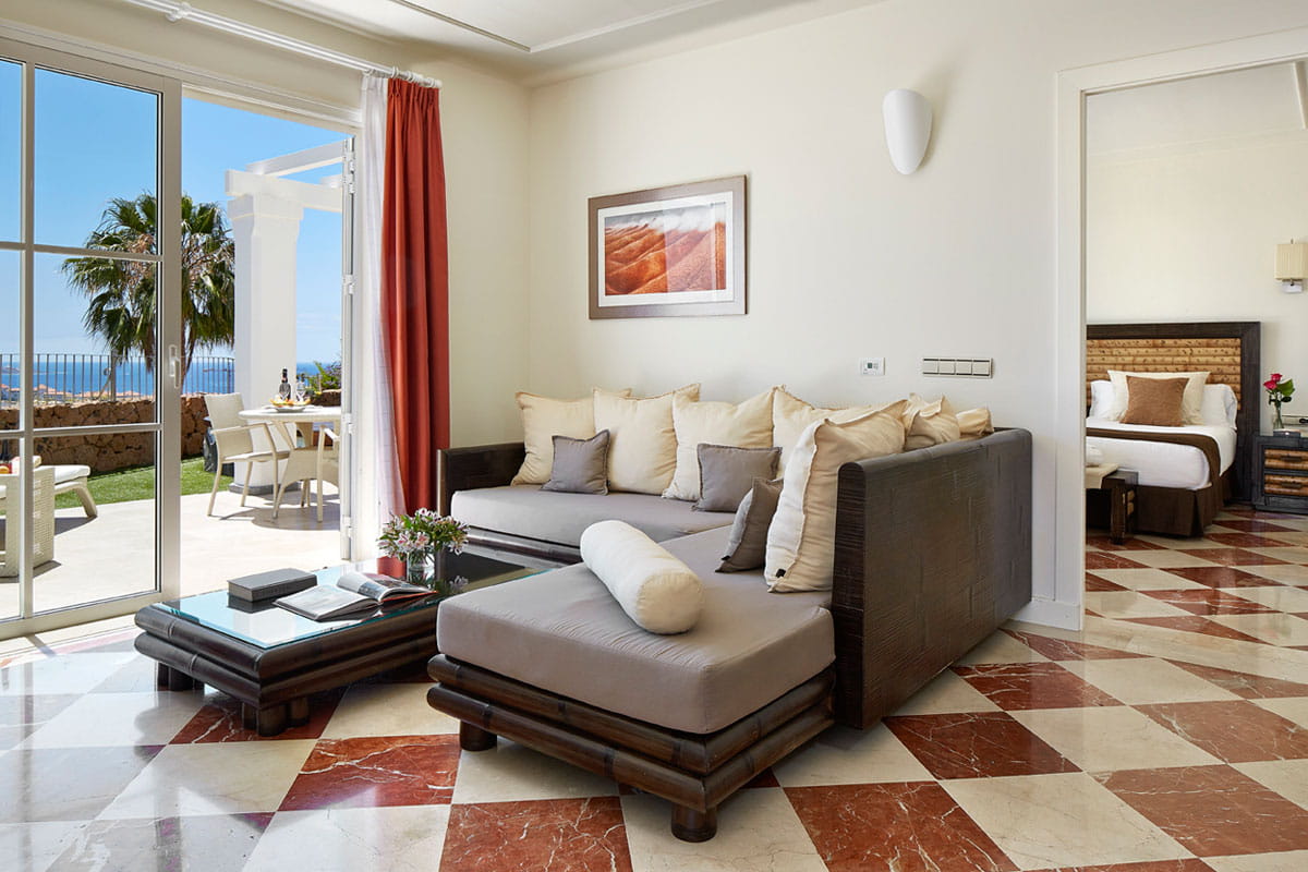 Living room with sofa and open patio door overlooking the sea in Tenerife.