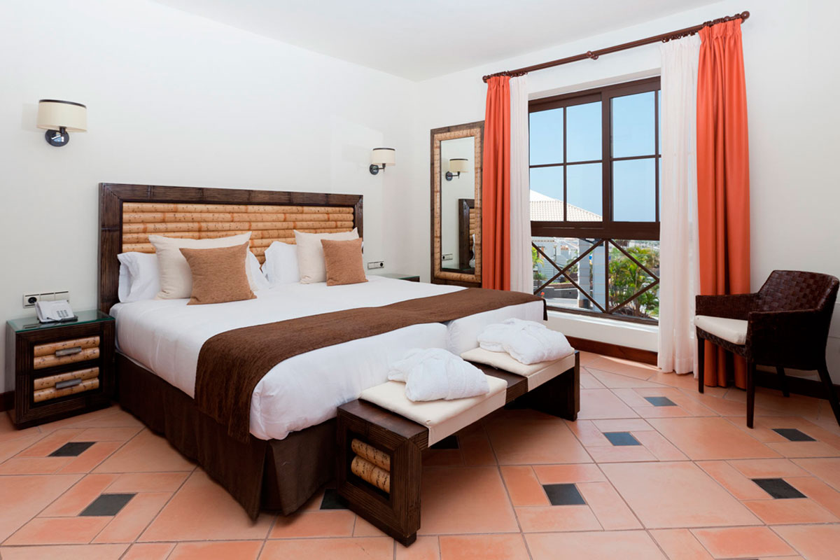 Bedroom with double bed and window view in Tenerife hotel room.