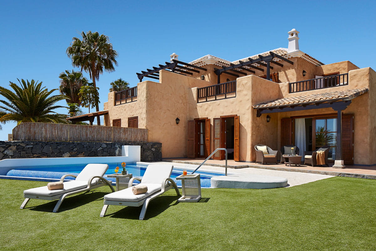 Luxury villa with pool and sun loungers in Tenerife garden.