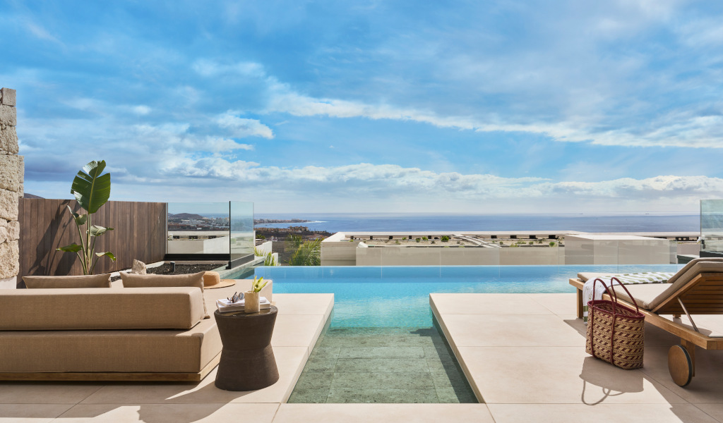 Infinity pool with ocean view and sunbeds in Tenerife.