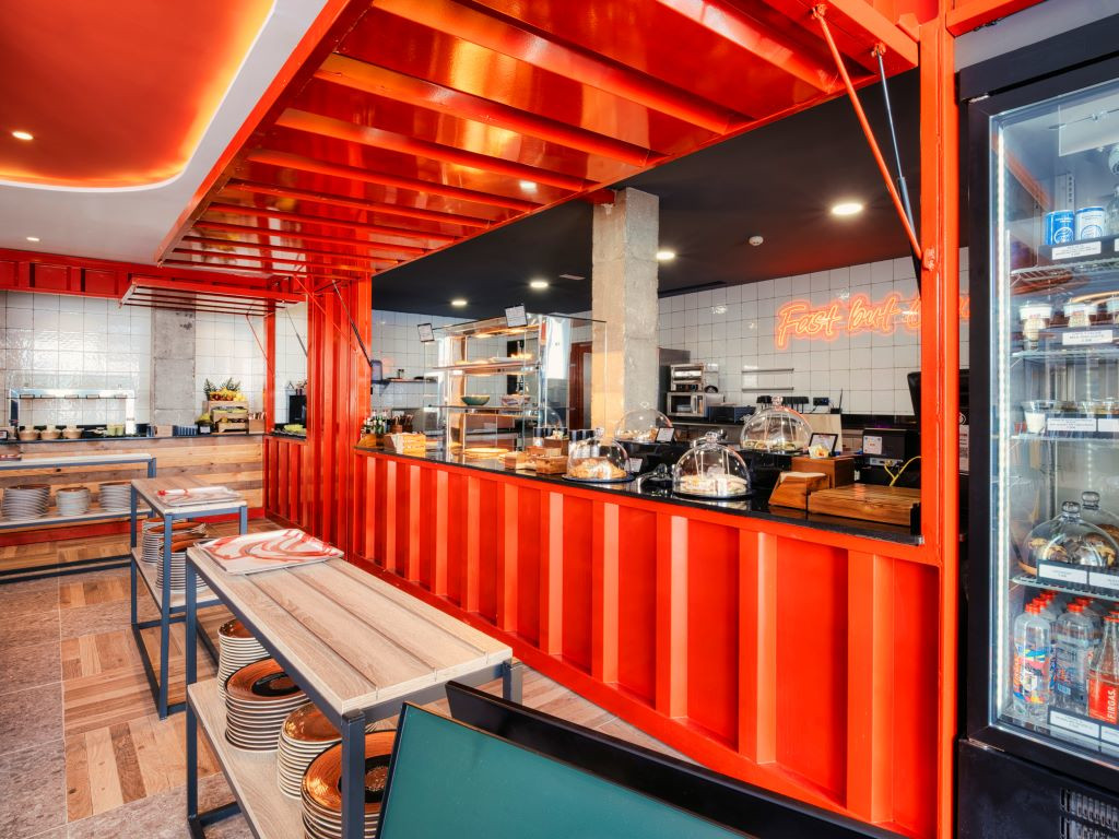 Interior of a restaurant in Tenerife with wooden tables and red counter.