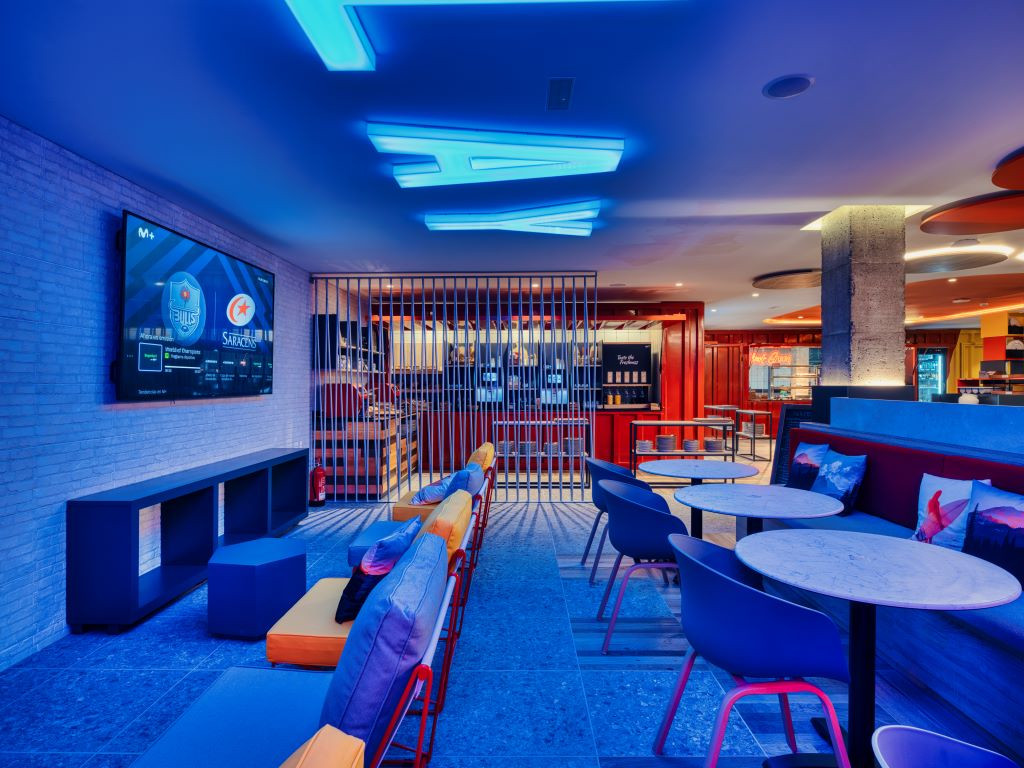 Illuminated rest area in Tenerife bar with screen and tables.