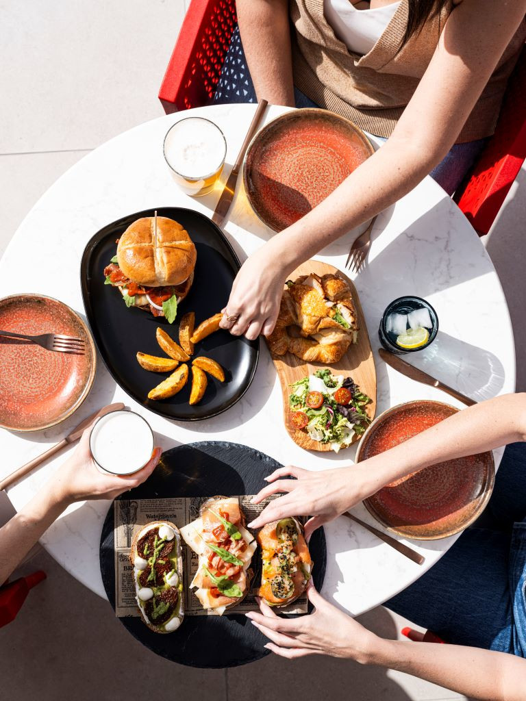 Table with hamburger, fries, salad and drinks in a restaurant in Tenerife.