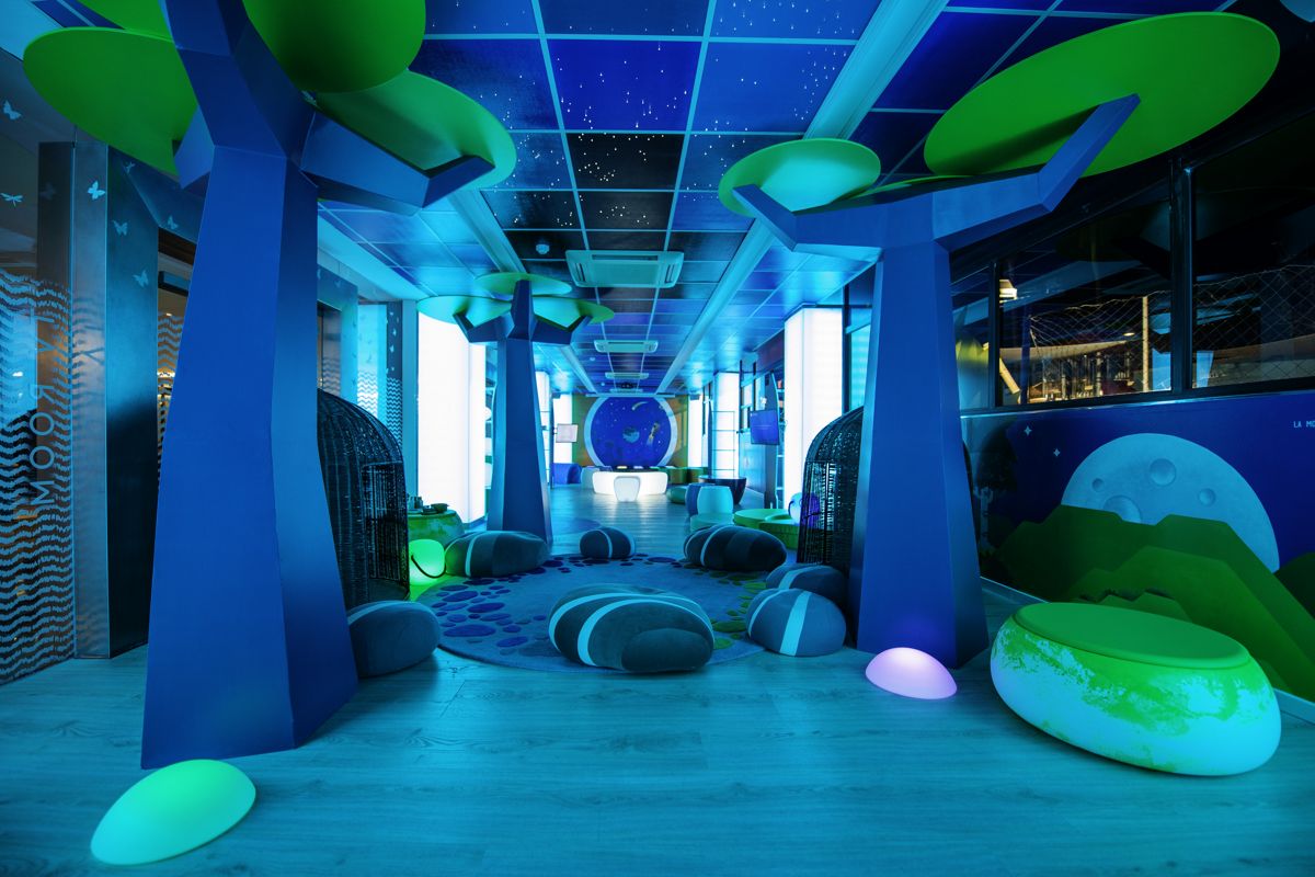 Colorful indoor play area with artificial trees and large cushions in Tenerife.