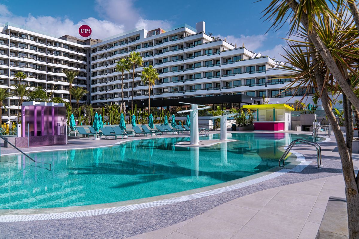 Outdoor pool area with sun loungers at a modern hotel in Tenerife.
