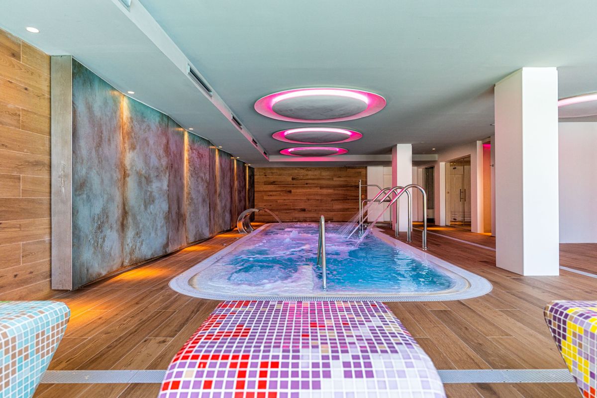 Indoor pool with massage jets and colorful ceiling lights in Tenerife.