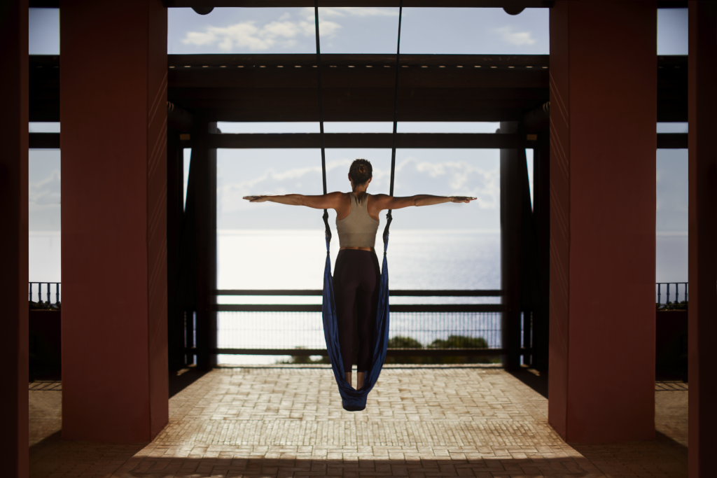 Person doing aerial yoga overlooking the ocean in Tenerife.
