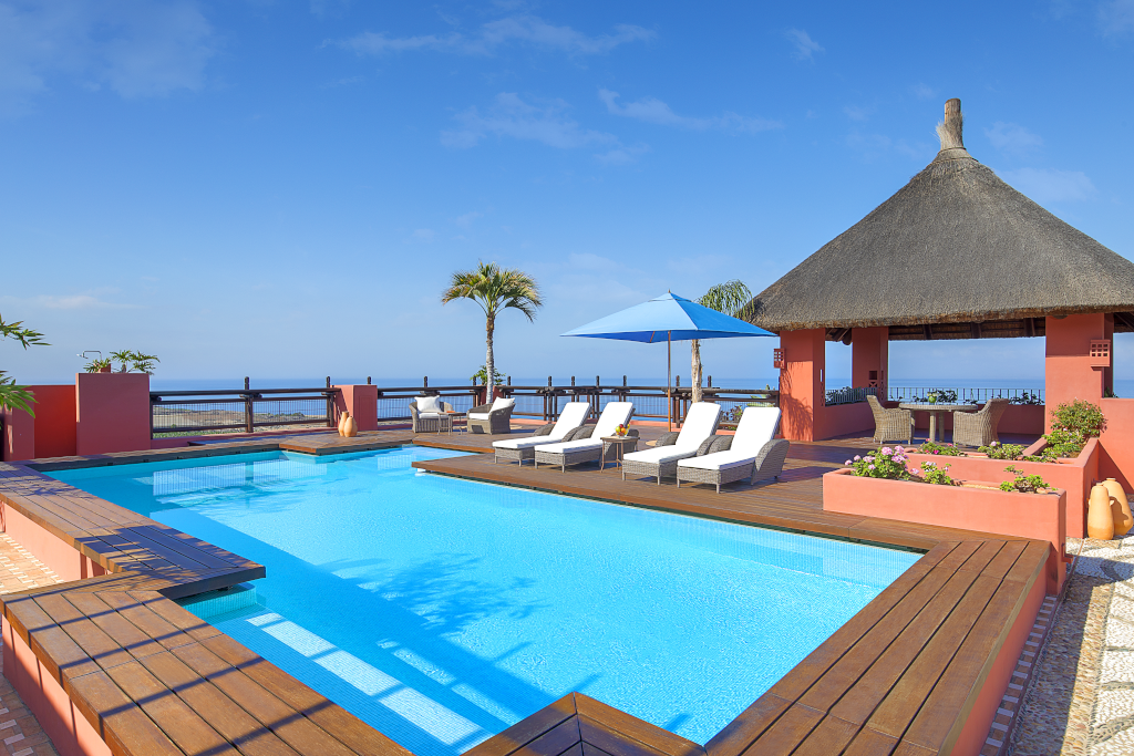Poolside lounge and thatched gazebo with ocean view in Tenerife.