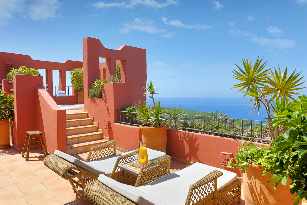 Terrace with lounge chairs and ocean view in Tenerife garden.