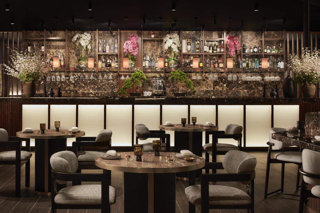 Dining area with tables, chairs, and a bar with bottles and flowers in Tenerife.