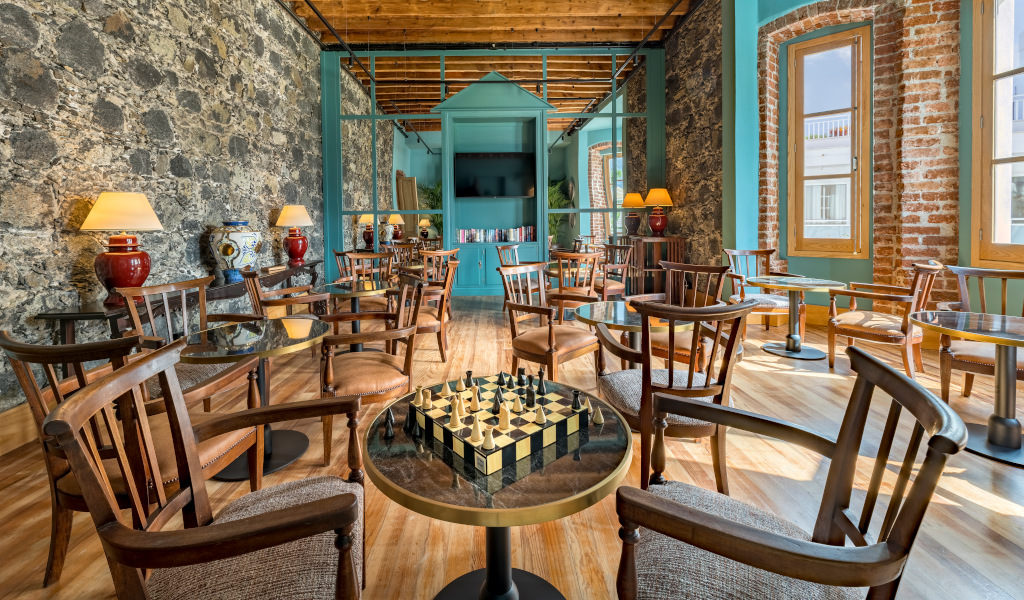 Cozy café in Tenerife with wooden chairs and a chessboard on a glass table.