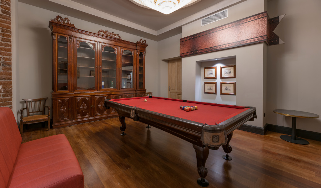 Billiard table with red felt in a room with wooden furniture in Tenerife.