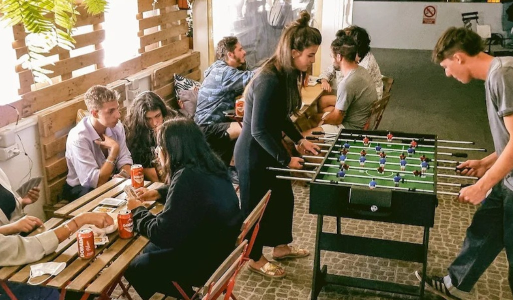 People playing foosball and cards at a cafe in Tenerife.