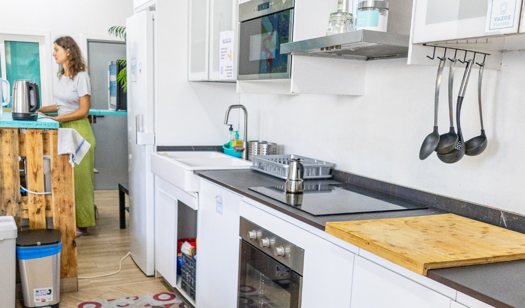Modern kitchen in Tenerife with woman at counter, appliances, and utensils.