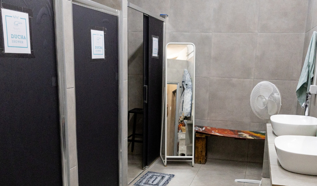 Showers and sinks in a bathroom with a fan and a mirror in Tenerife.