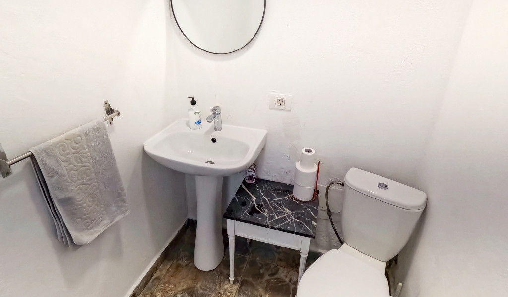 Bathroom with a sink, mirror, and toilet in Tenerife.