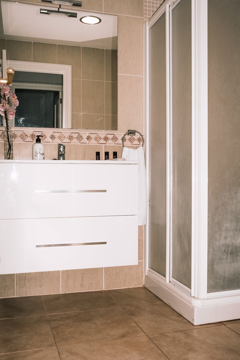 Bathroom with white cabinet and shower in Tenerife.