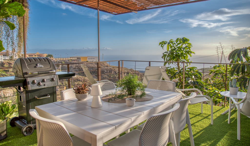 Outdoor patio with grill and dining table overlooking the sea in Tenerife.