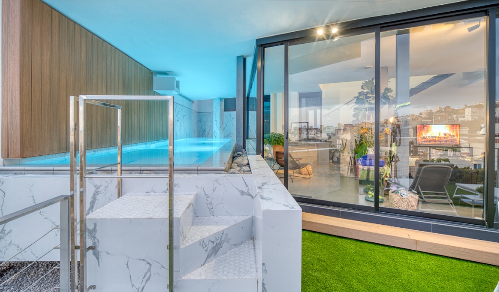 Indoor pool with marble steps and a glass wall overlooking Santa Cruz de Tenerife.