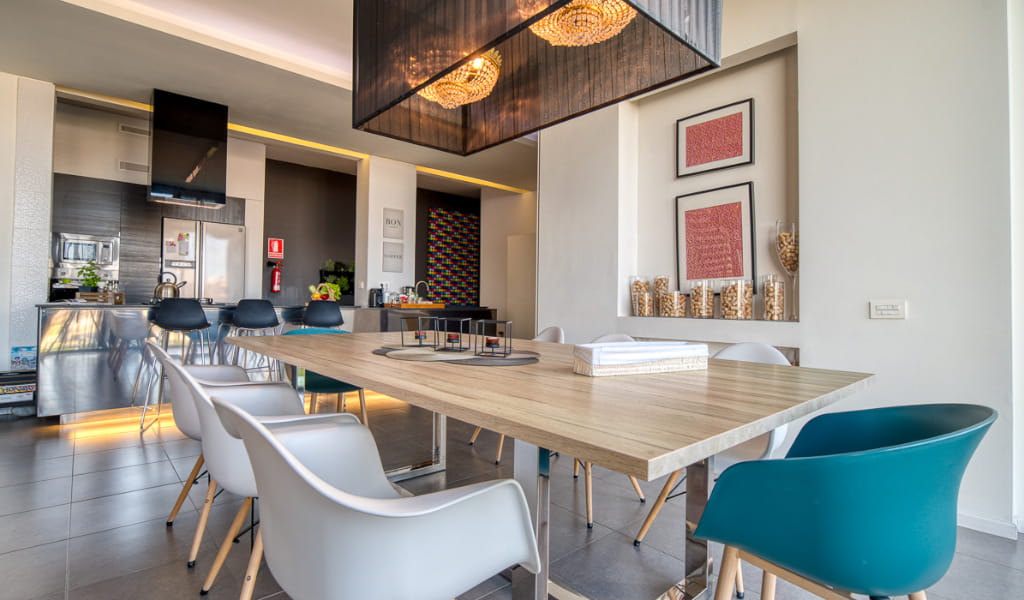 Modern kitchen and dining area with chairs, table, and artwork in Tenerife.