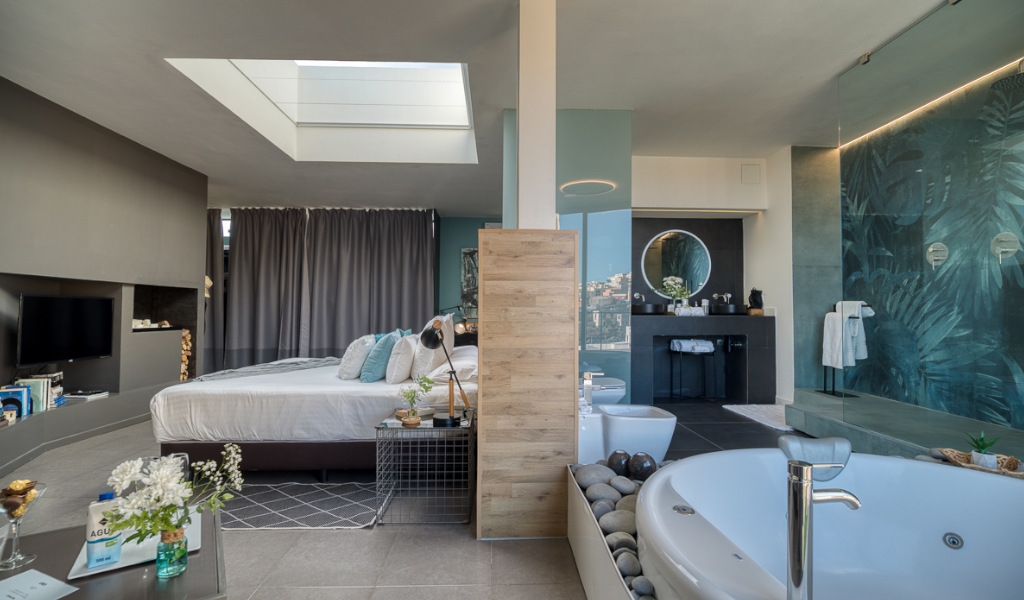 Luxury suite with modern decor, jacuzzi, bed, and bathroom in Tenerife.
