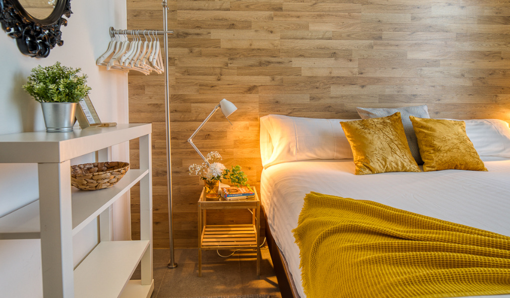 Hotel room with a cozy bed, wooden headboard, and decorative pillows in Tenerife.