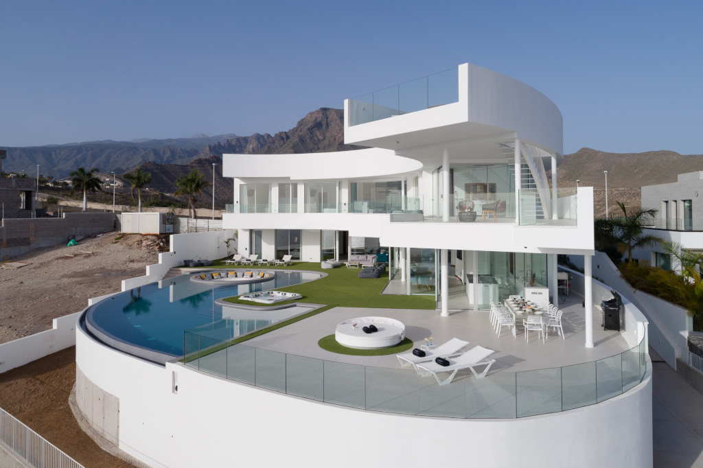 Modern villa with pool and terrace in Adeje, Tenerife, surrounded by mountains.