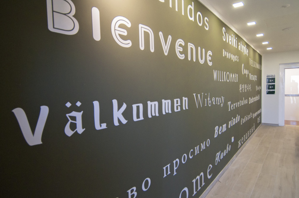 Bienvenidos and Welcome in various languages on wall in a Tenerife hallway.