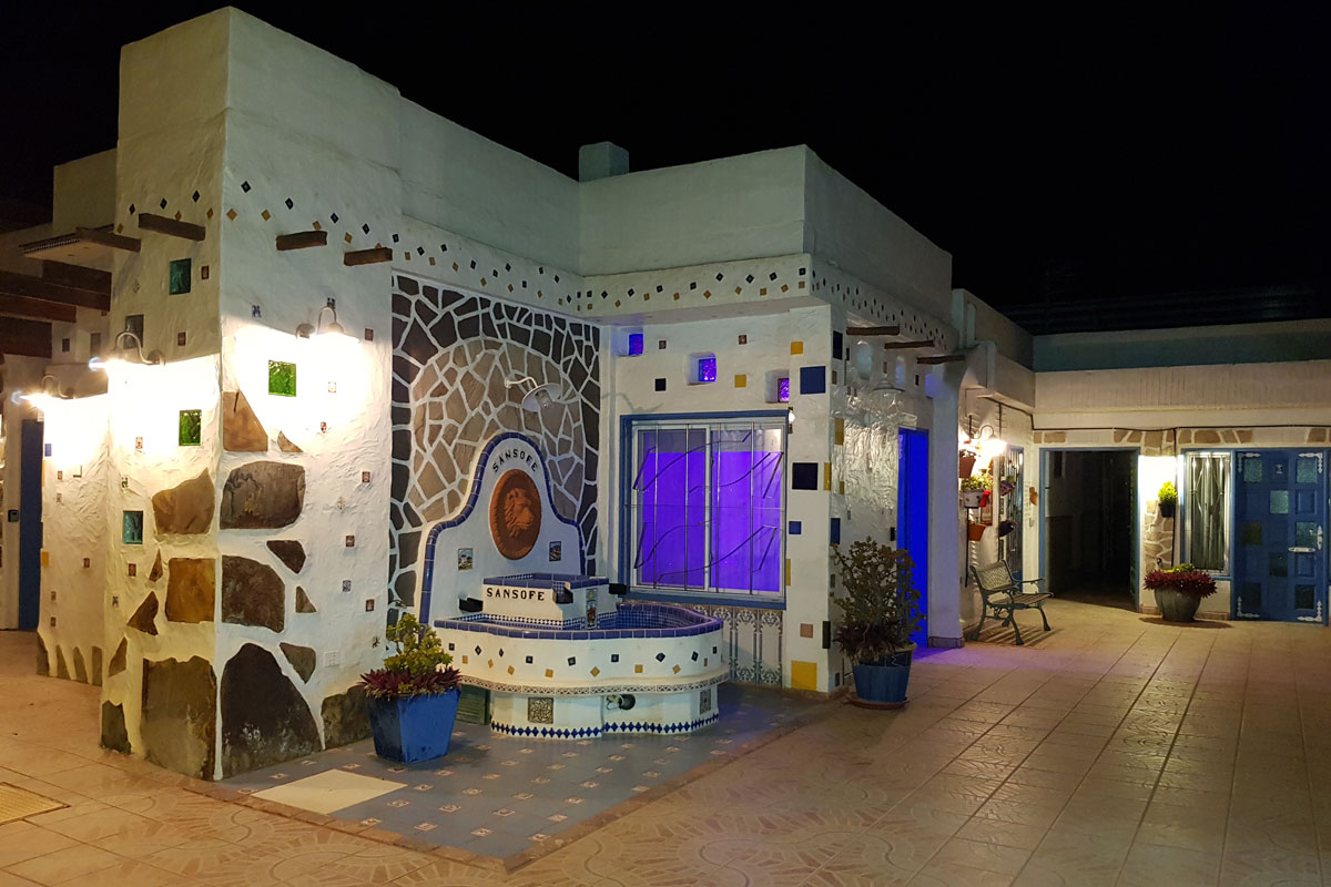 Building facade at night with mosaic tiles and SansoFe sign, Tenerife.