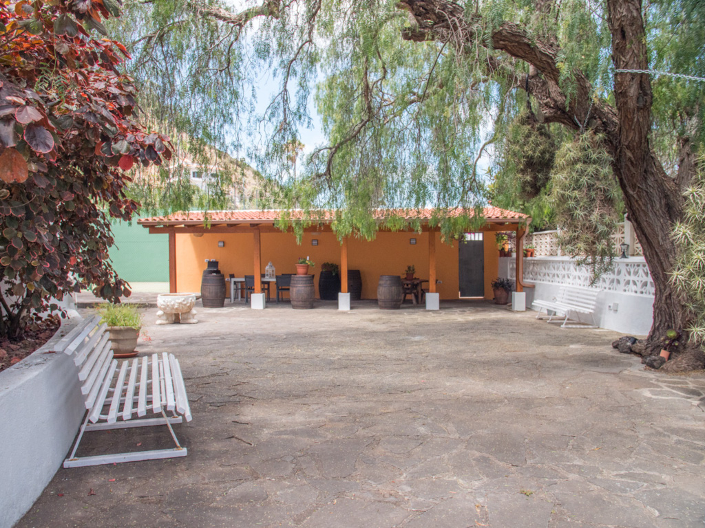 Courtyard with benches, barrels, and trees at a location in Tenerife.
