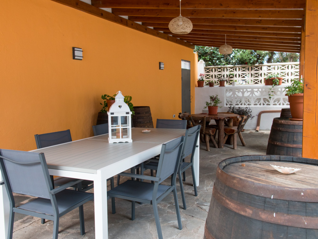 Outdoor patio with tables, chairs, and plant pots in a Tenerife location.