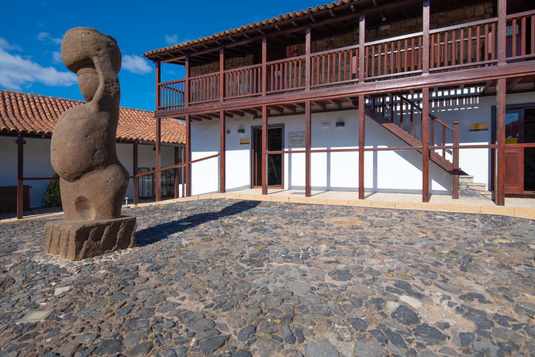 Stone sculpture and wooden building in Vilaflor, Tenerife.
