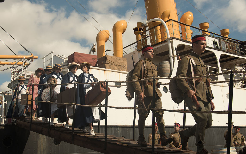 People disembarking a military ship with luggage in Tenerife.