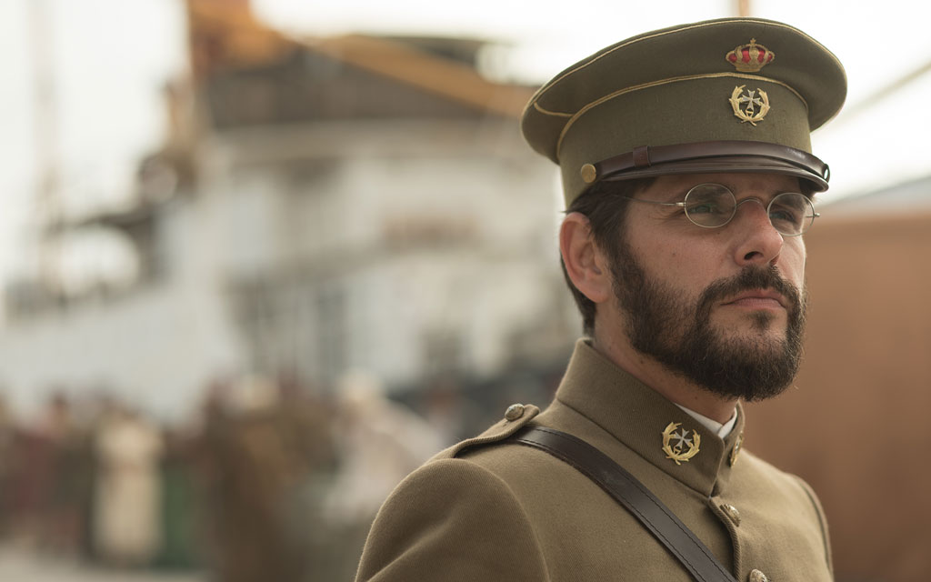 Military officer in period uniform next to a ship in Tenerife.