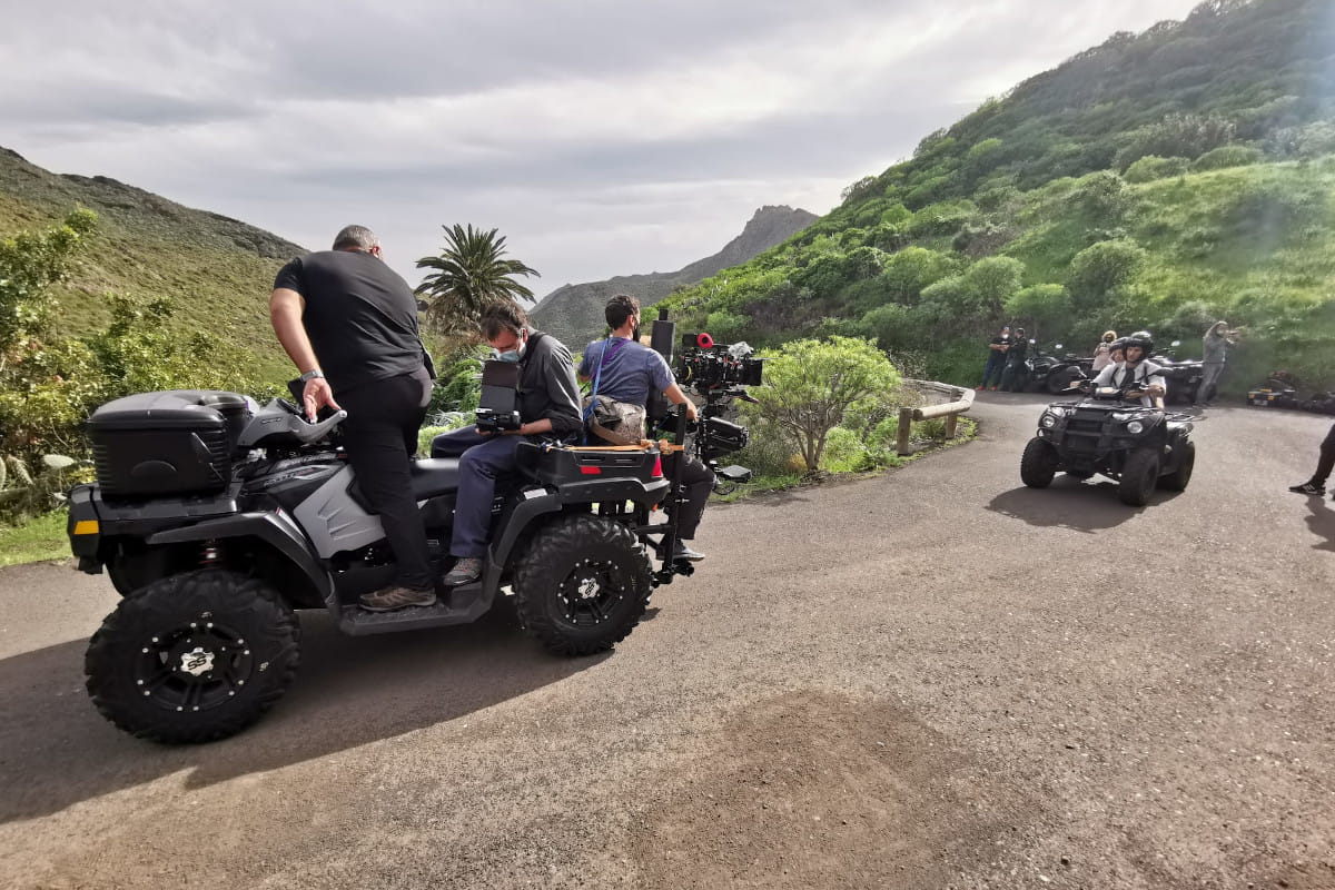 People on quad bikes with film equipment on a mountainous road in Tenerife.