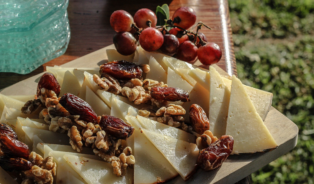 Tenerife cheese on a board with walnuts, dates and red grapes in Tenerife.