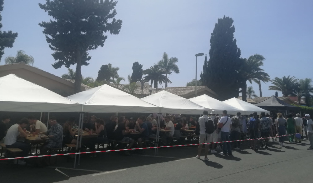 People having lunch under tents at an outdoor event in Tenerife.