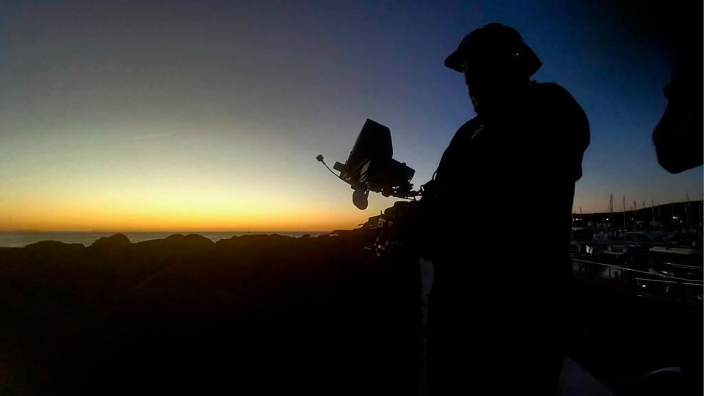Person with camera equipment at sunset in the port of Los Cristianos, Tenerife.
