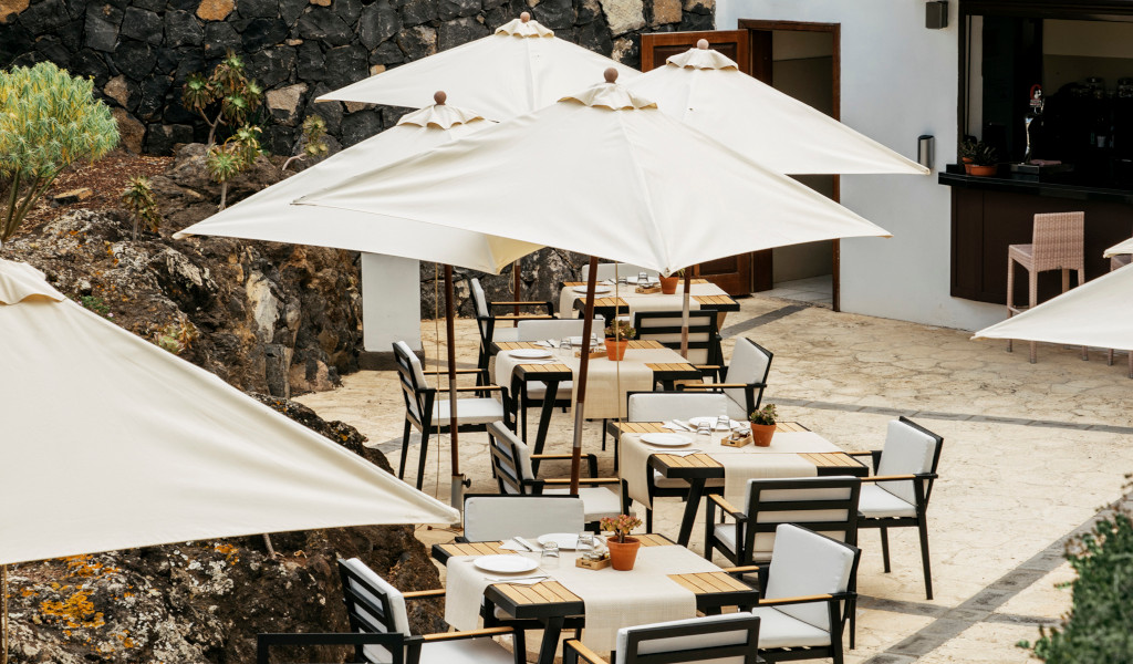 Terrace with tables and parasols in an open-air restaurant in Tenerife.
