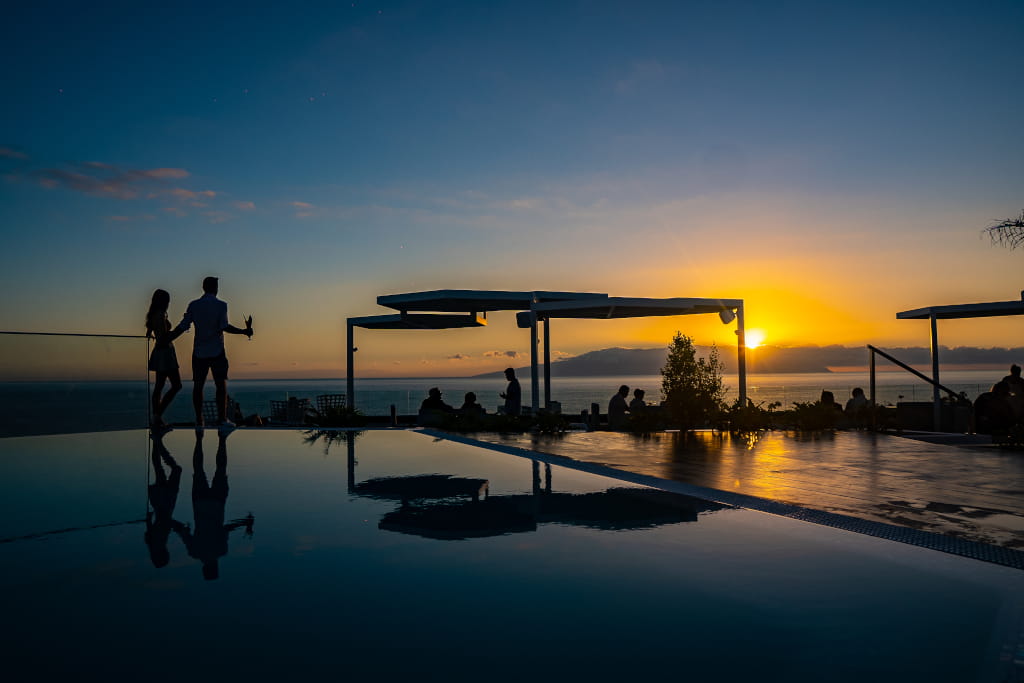 Couple on terrace at sunset in front of the sea in Tenerife.