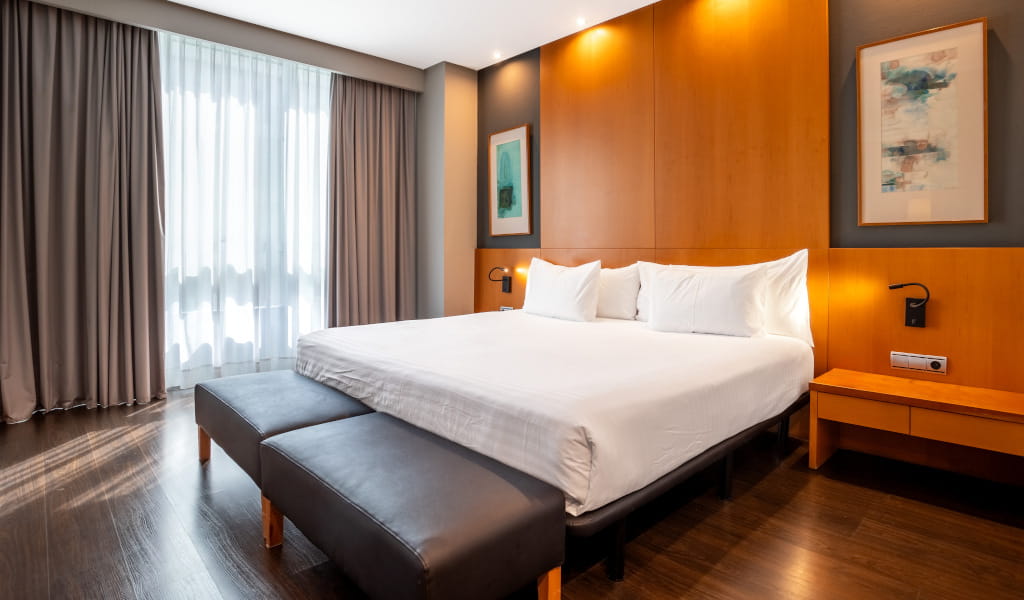Double bed with white pillows in a modern style room in Tenerife.