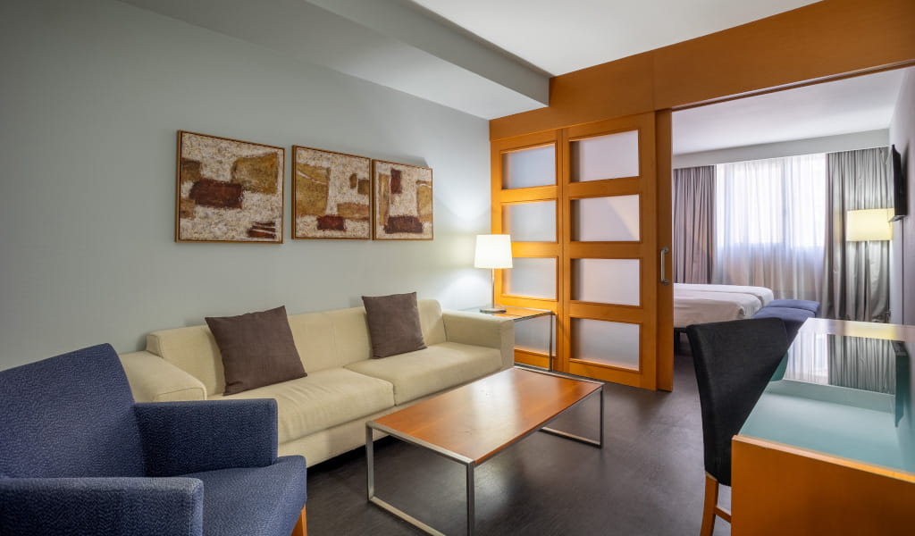 Hotel living room in Tenerife with sofa, table and artwork on the wall.