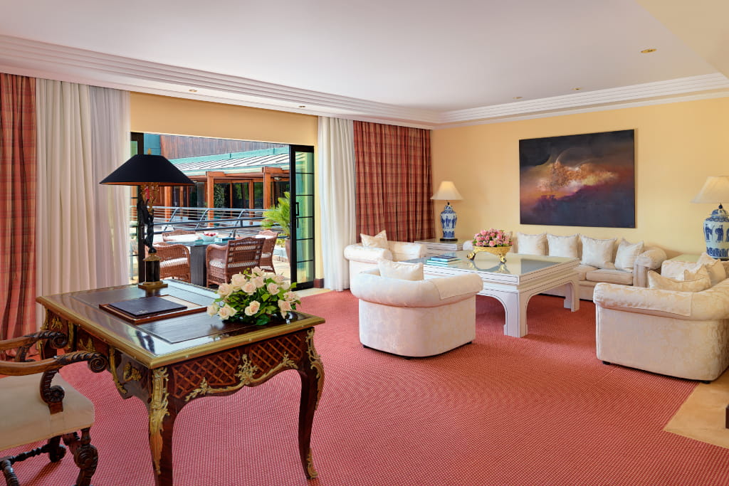 Living room with wooden desk, beige sofas and doors open to the outside in Tenerife.