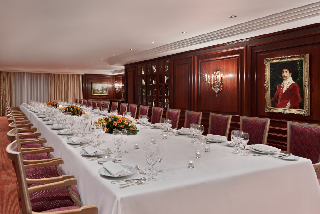 Elegant dining table with red chairs and pictures in a room in Tenerife.