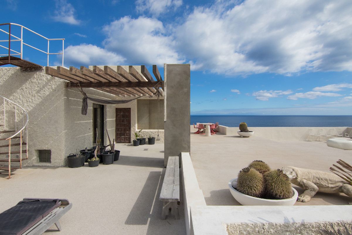 Terrace with sea views in Tenerife, with chairs, cactus and iguana decoration.