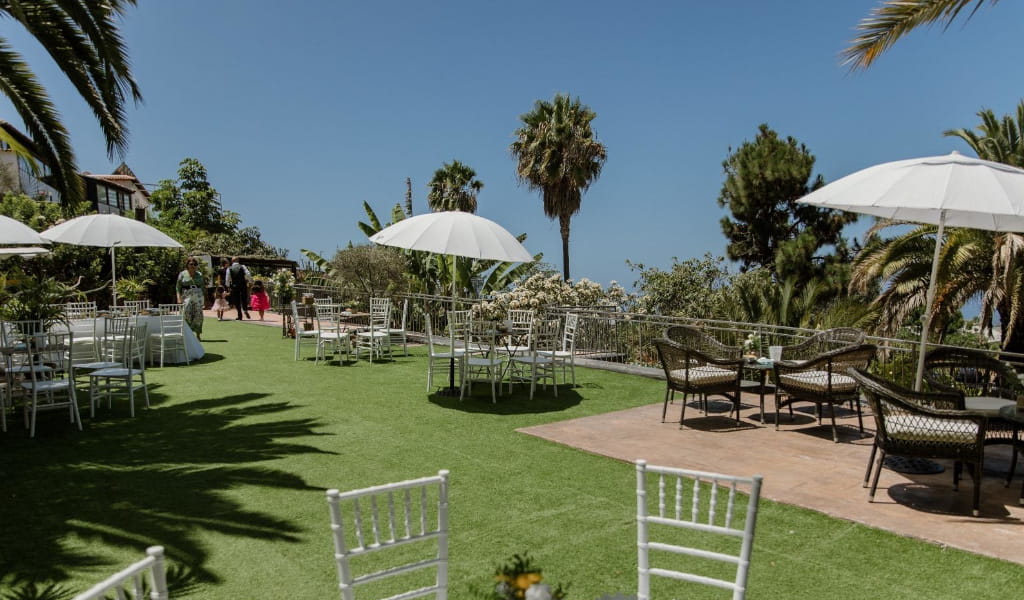 Garden with chairs and tables under umbrellas in a place in Tenerife.