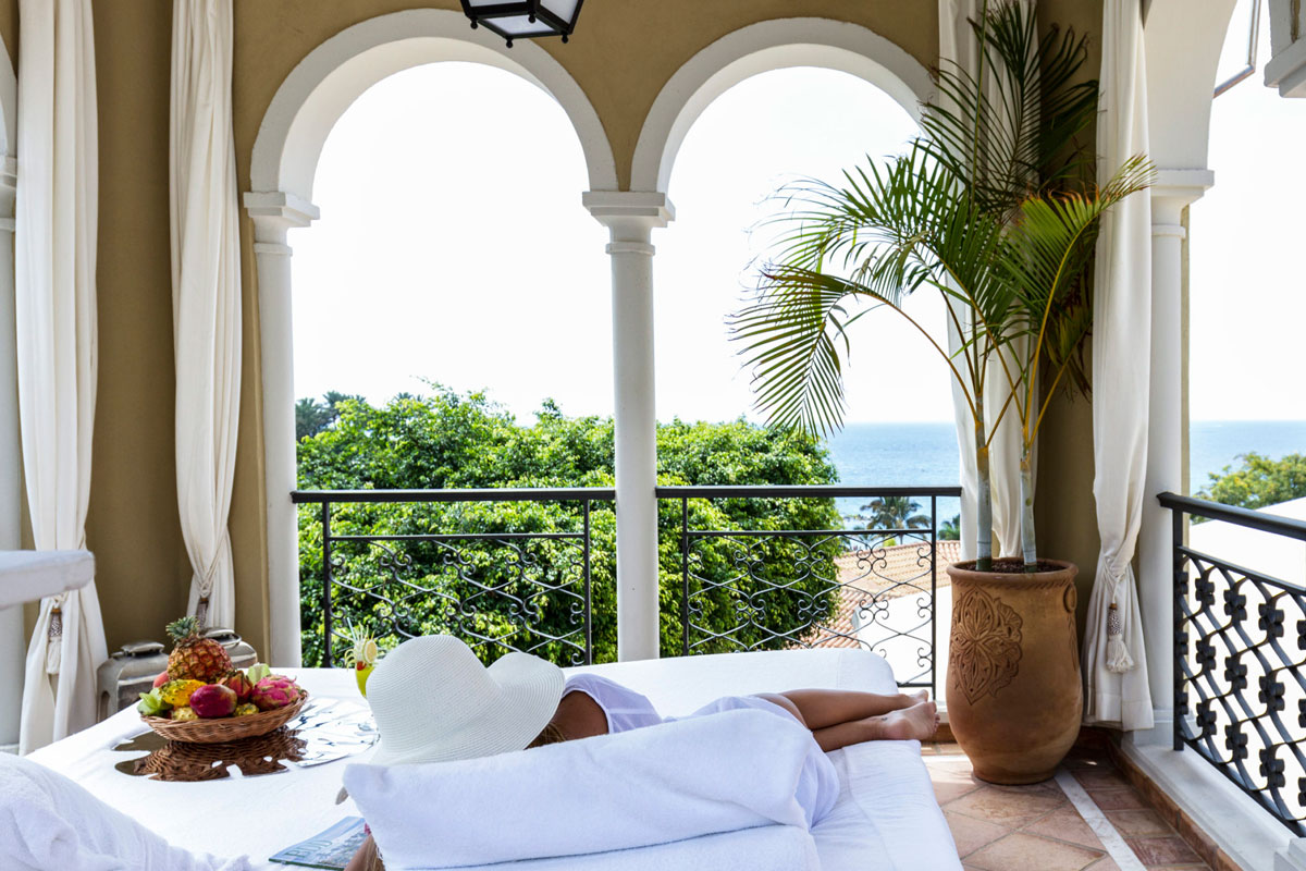 Person lounging on terrace with sea view in Tenerife.