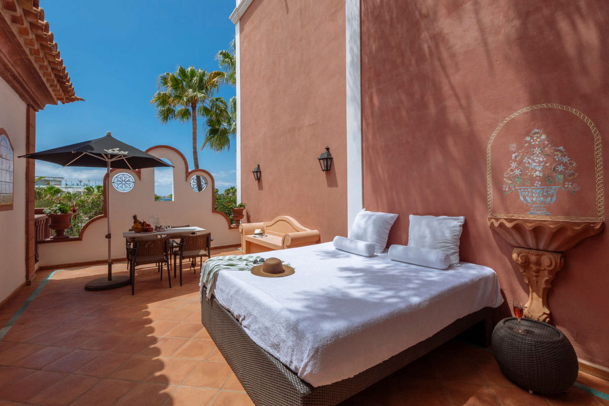 Terrace with bed and table under parasol in Tenerife.
